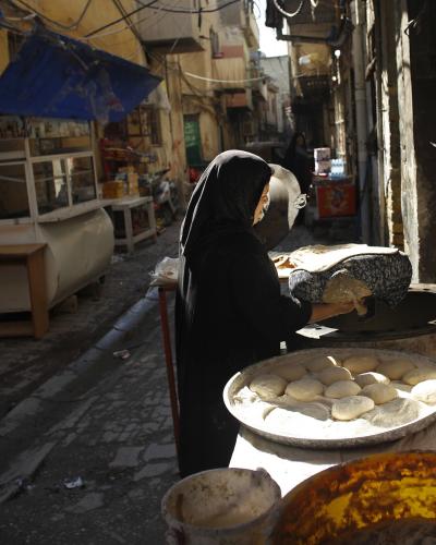 A woman bakes bread in the streets of Baghdad.